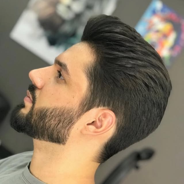 Cliente de perfil com corte social degradê e barba alinhada