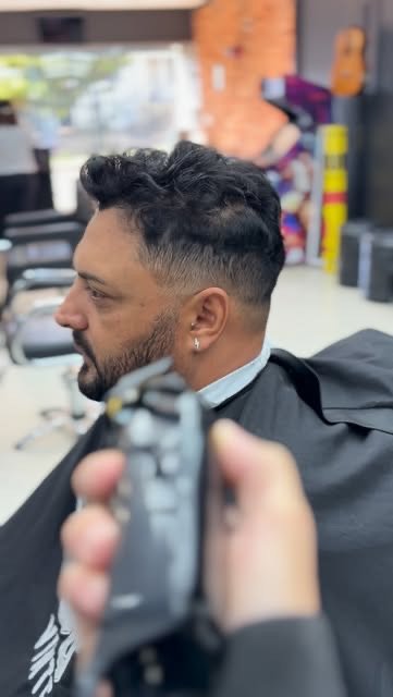 Degradê baixo com topete ondulado e barba